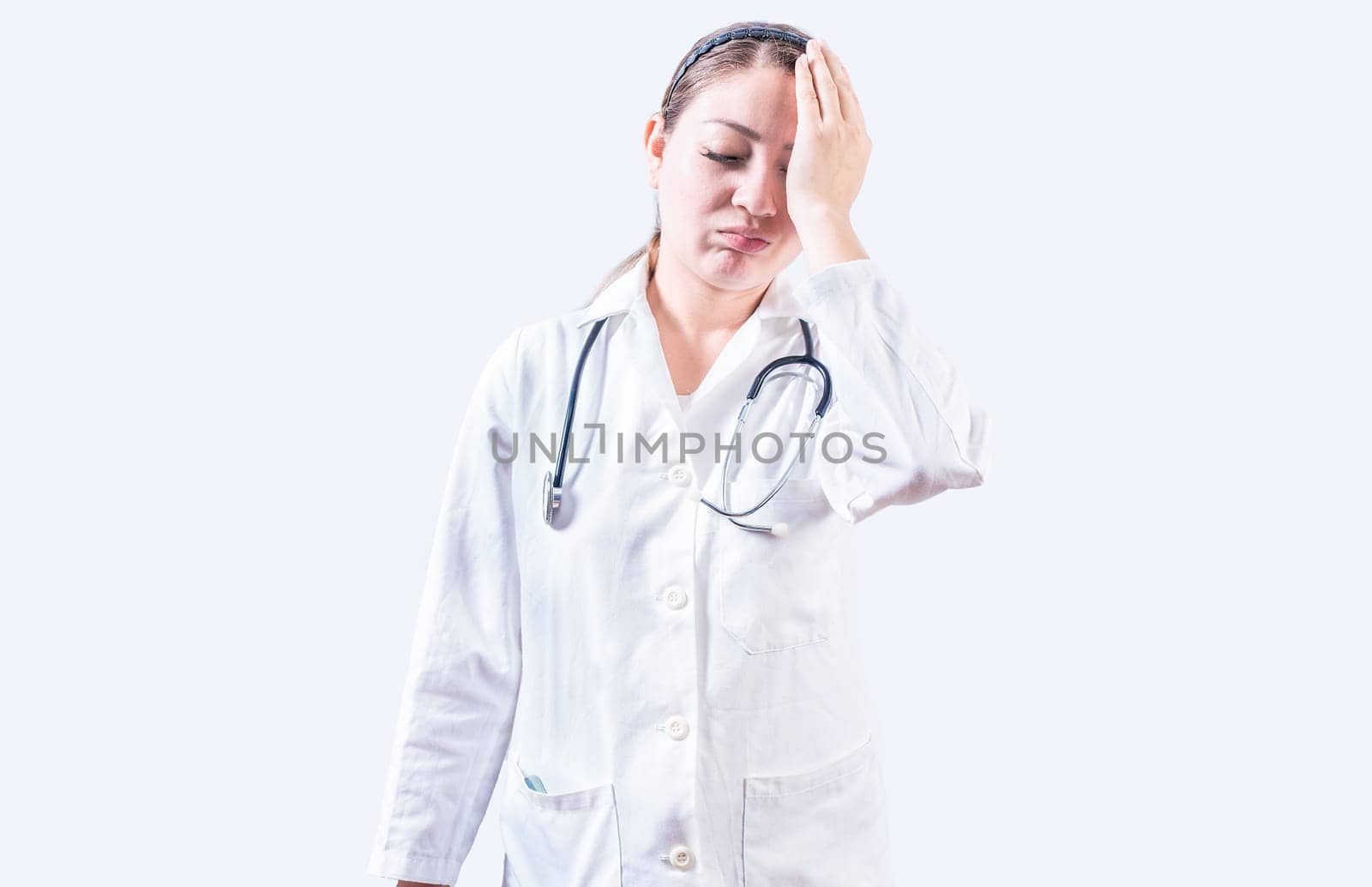 Exhausted female doctor with hand on forehead. Tired young female doctor with hand on forehead isolated by isaiphoto