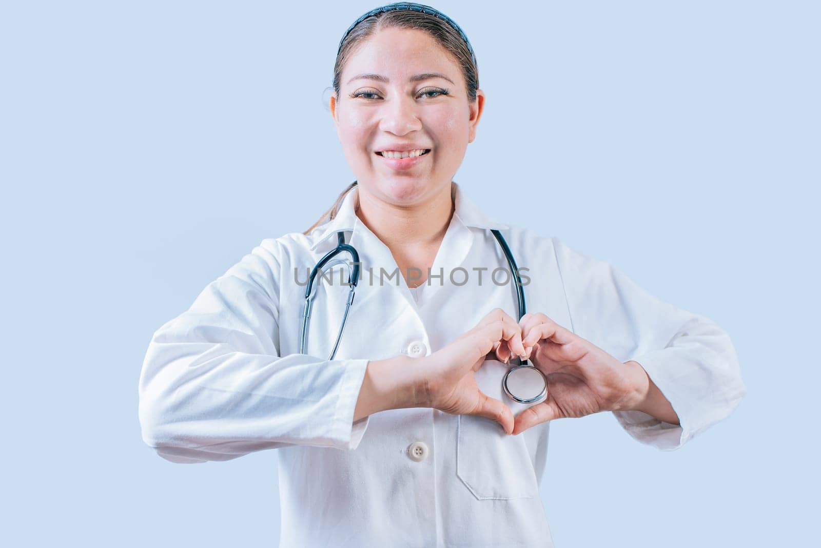 Smiling doctor making heart shape on isolated background. Friendly female doctor making heart gesture with hands isolated by isaiphoto