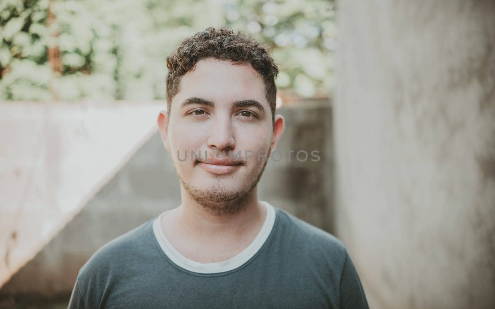 Portrait of cheerful young latin guy smiling at camera outdoors. Portrait of Latin American man looking and smiling at the camera by isaiphoto