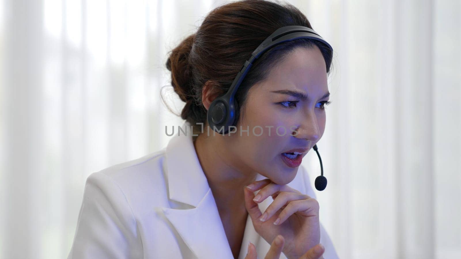 Businesswoman wearing headset working in office to support remote customer or colleague. Frustrated and tired call center customer support agent facing problem on providing vivancy service