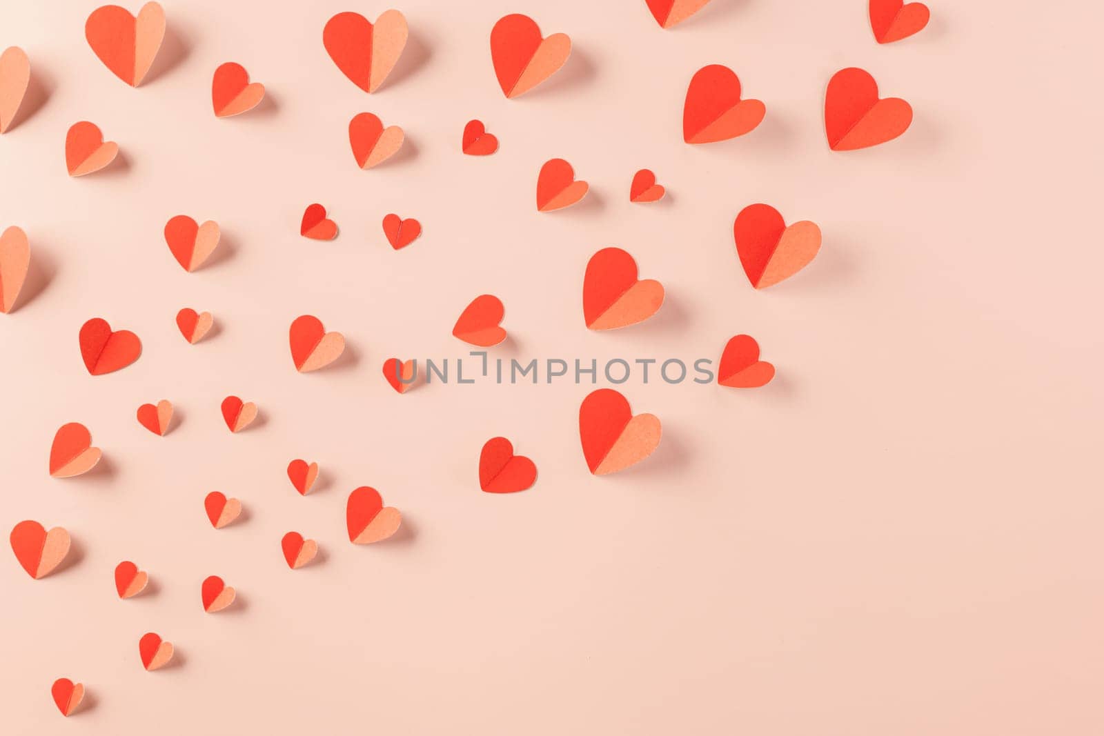 Happy Valentine's day concept. Symbol of love paper art with copy space for text, handmade red paper hearts shape cutting pastel pink background, Mother's Day