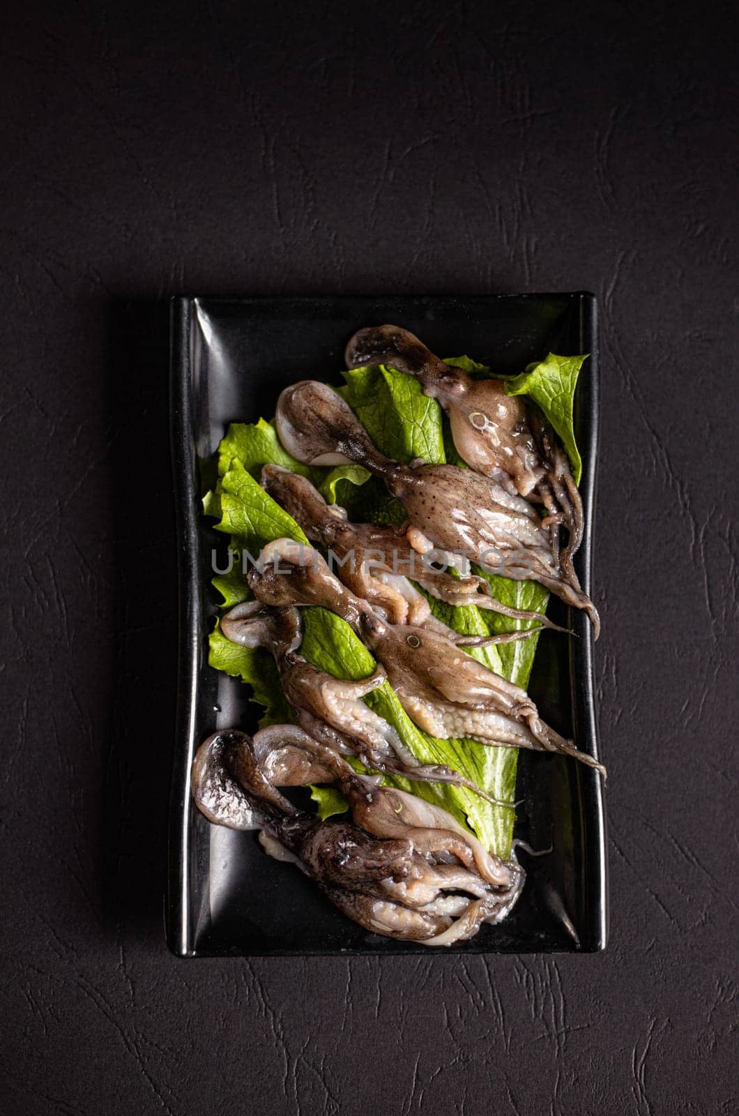 sliced ingredients in a flat black plate on a white background