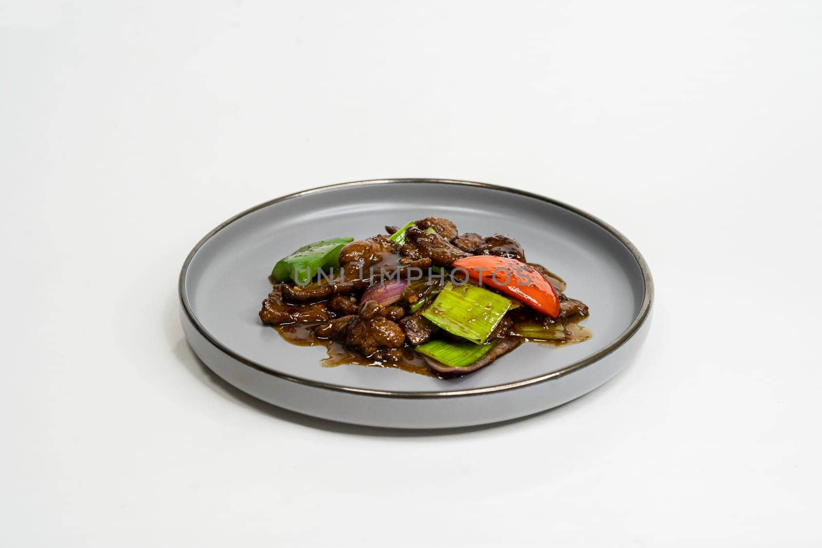 fried assorted vegetables with meat in a flat plate on a white background, side view by tewolf