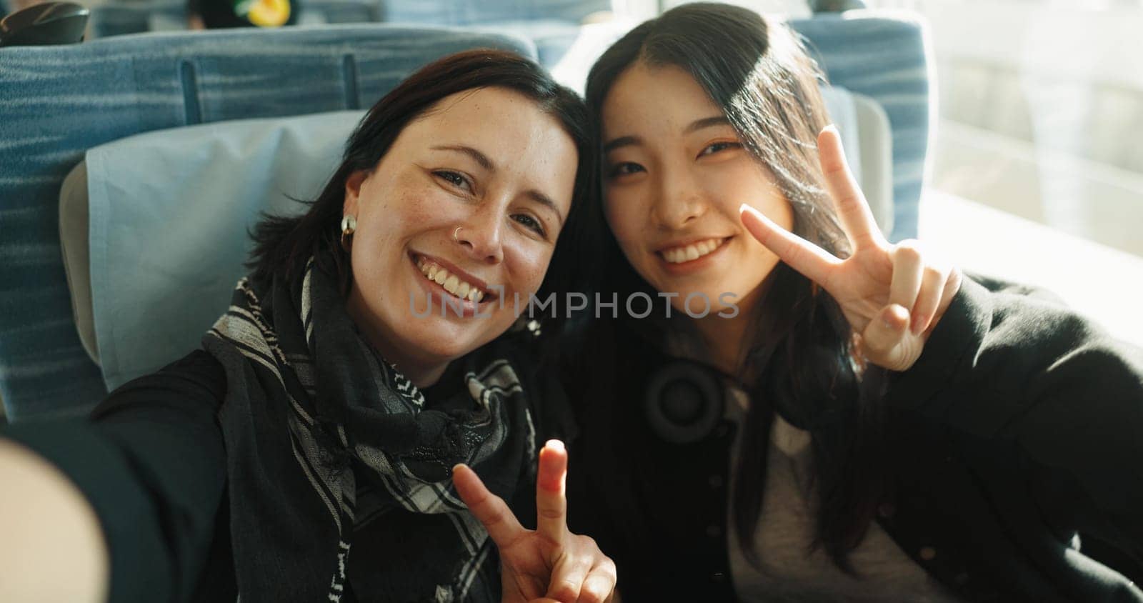 Women, peace sign and selfie on train, portrait and japan public transportation on metro bullet. Friends, emoji and happy face on fast vehicle on vacation trip and commute to tokyo city for adventure.