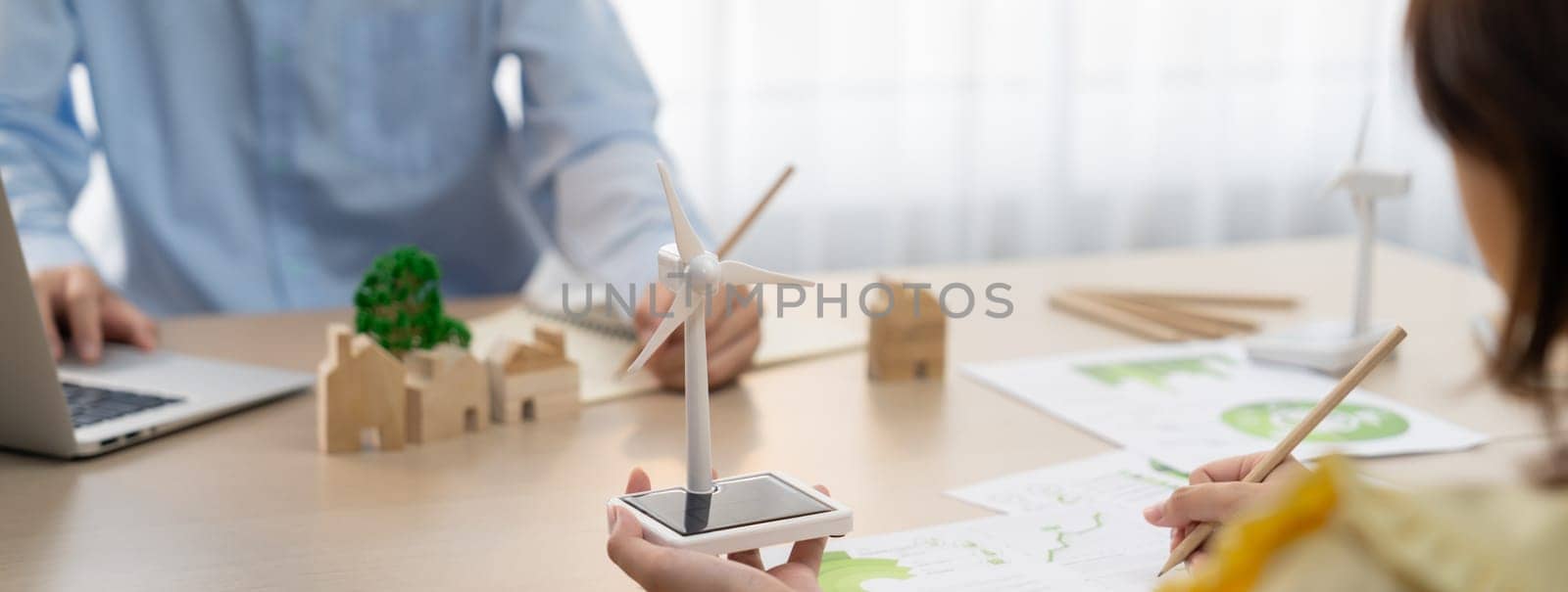 Businesswoman interested in investing in renewable energy at meeting table with environmental document scatter around. Business team discussion about green business project. Closeup. Delineation.