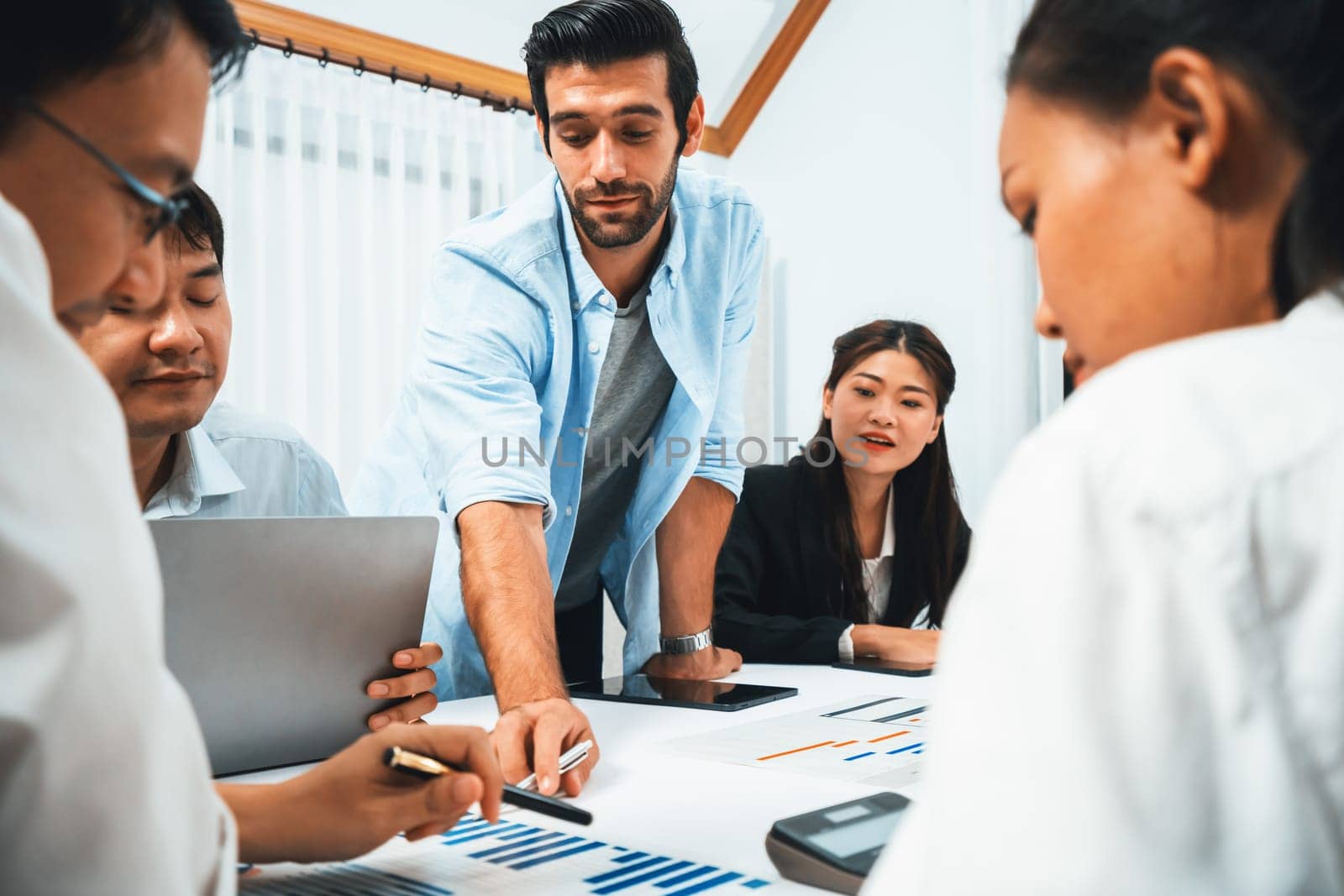 Analyst team utilizing BI Fintech to analyze financial data at table in meeting room. Businesspeople analyzing BI dashboard power on paper for business insight and strategic marketing planning.Prudent