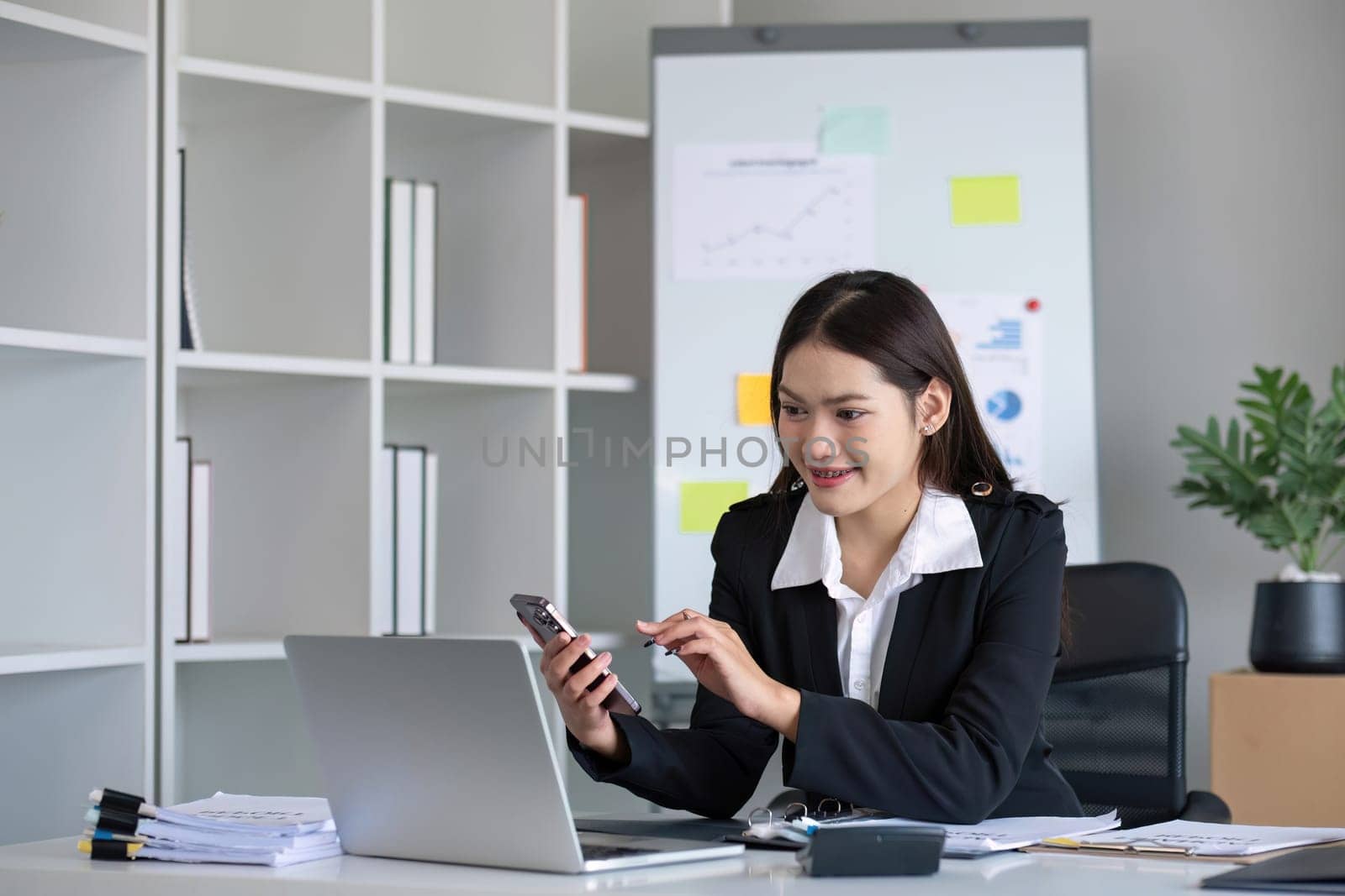 Happy asian business woman have the joy of talking on the smartphone, tablet and laptop on the modern office.