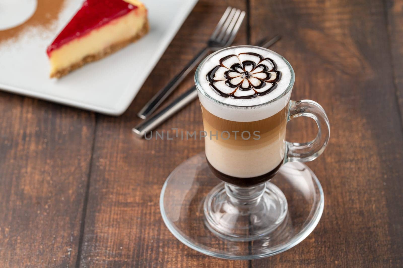 Multilayer coffee latte in glass cup on wooden table