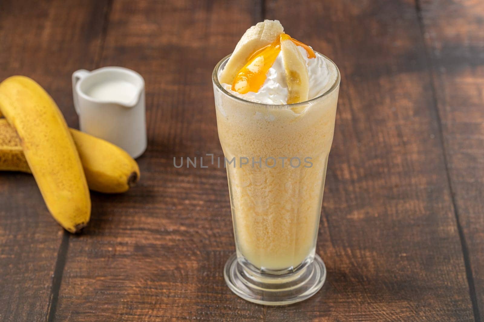 Banana smoothie in glass cup on wooden table