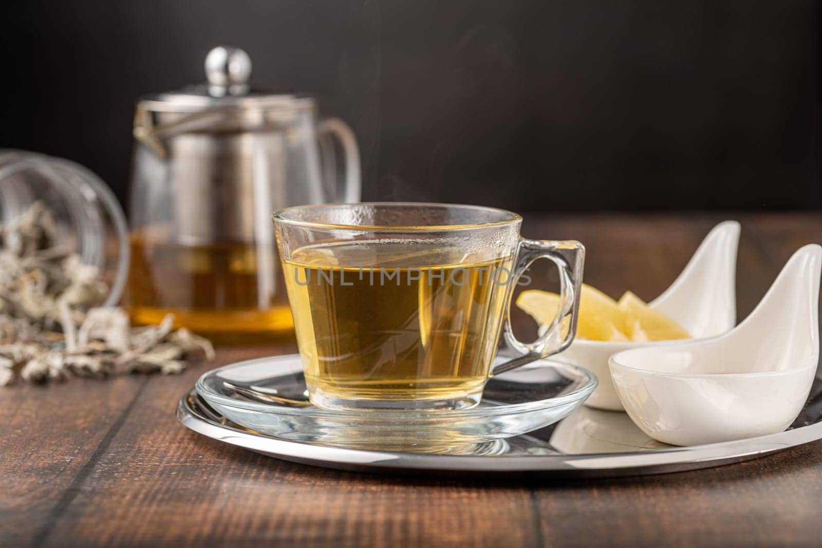 Dried sage tea in glass cup on wooden table by Sonat