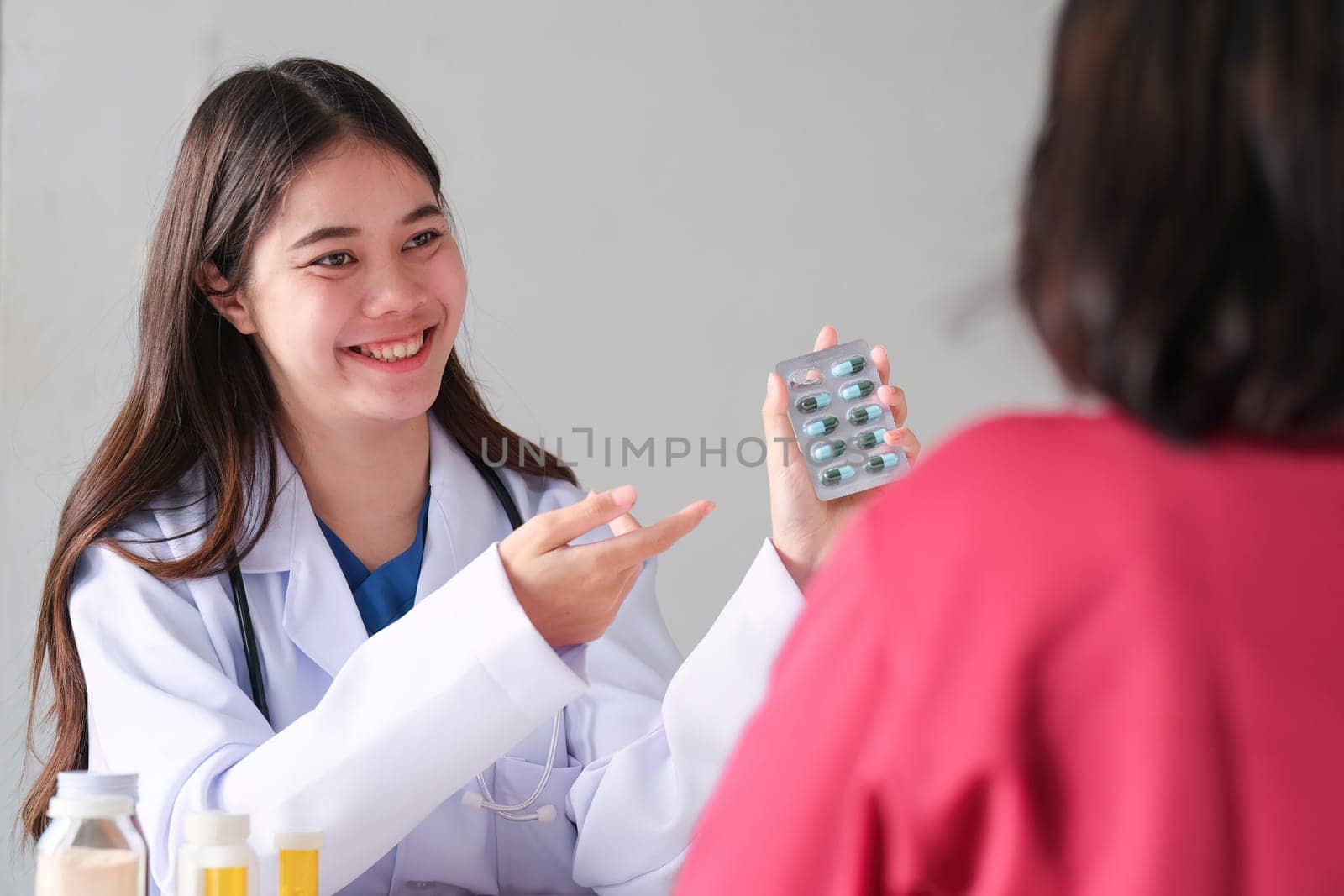 An Asian female doctor is consulting a patient who comes to discuss taking medication for health care. and treat disease with medicine.