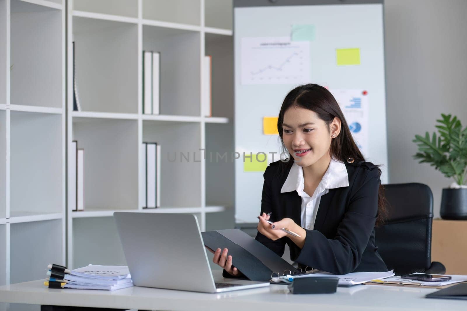 Business documents, business auditor Asian woman is reviewing legal documents, preparing documents or reports for analysis tax accountant documents agreement contract information in office at work.