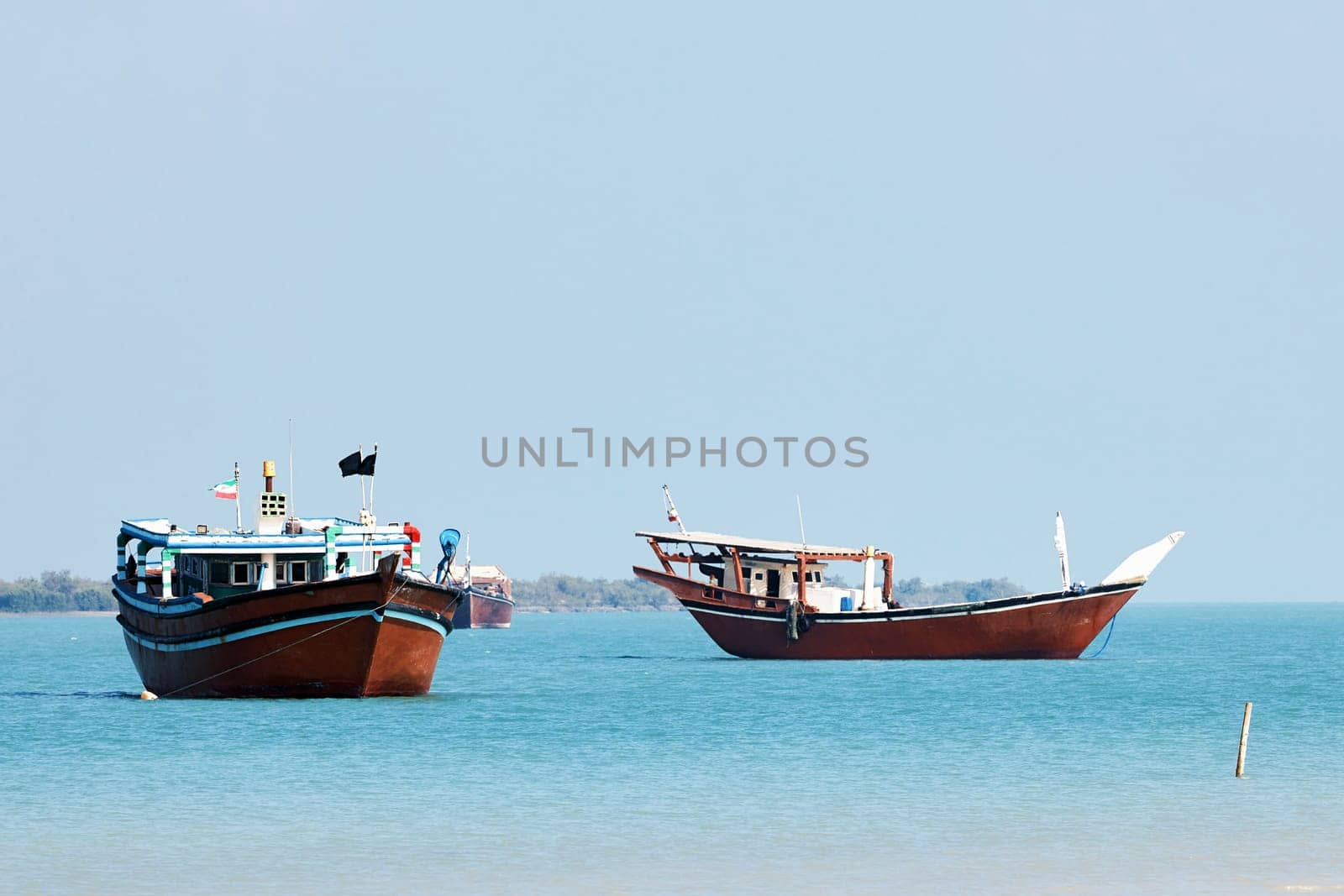 Traditional Dhow old wooden boat in the harbor of Iranian Qeshm Island. Tradition Lenj Fishing Boat in Qeshm Island in Southern Iran. Old wooden stealth smuggler's ship.