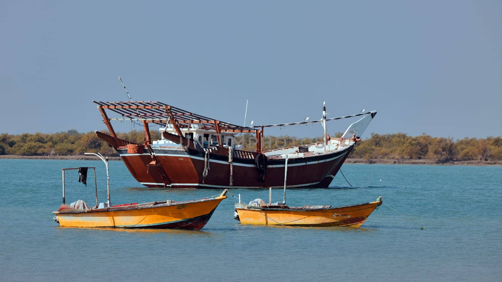 Traditional Dhow old wooden boat in the harbor of Iranian Qeshm Island. Tradition Lenj Fishing Boat in Qeshm Island in Southern Iran. Old wooden stealth smuggler's ship by EvgeniyQW