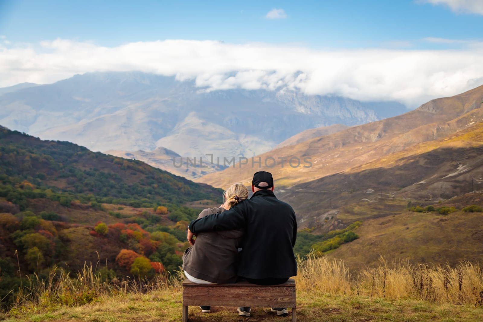 Hugging couple in the mountains enjoying the scenery by Yurich32