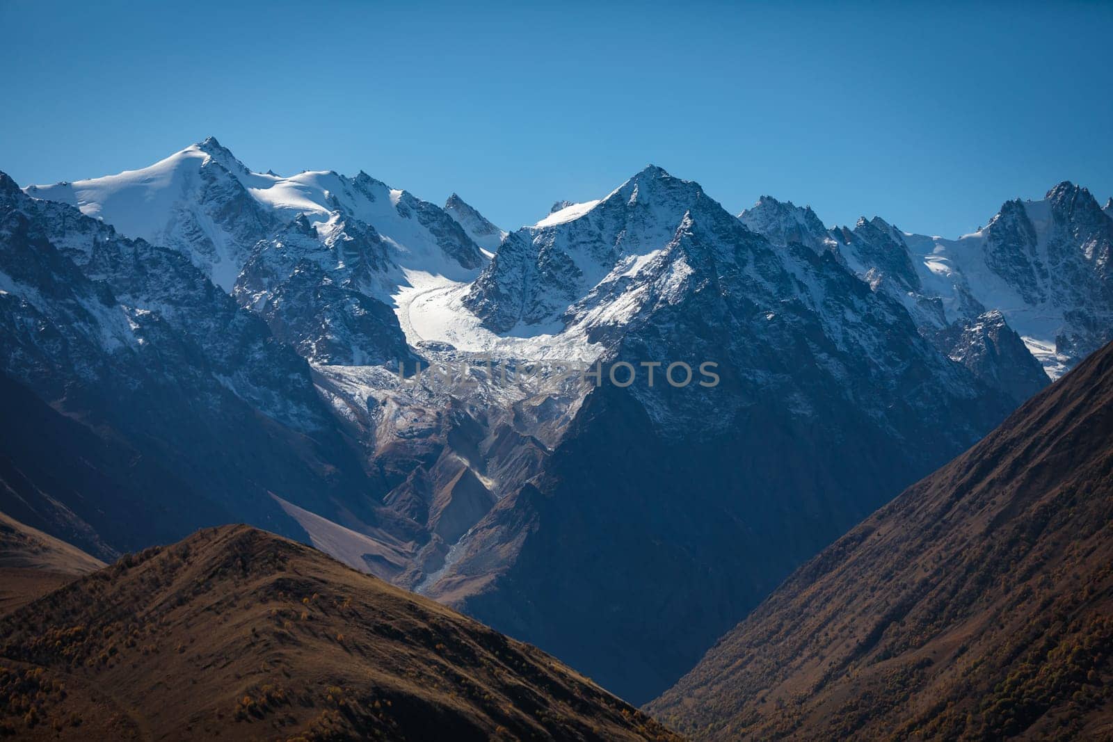 Snow-capped mountains rise majestically along the horizon by Yurich32