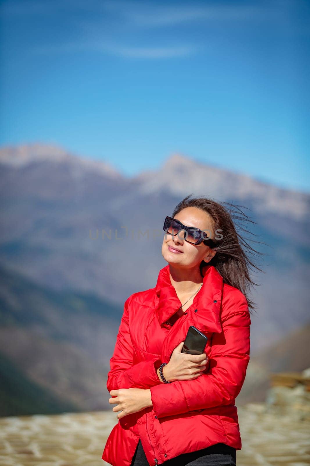 Young beauty posing in front of a snow-capped mountain peak