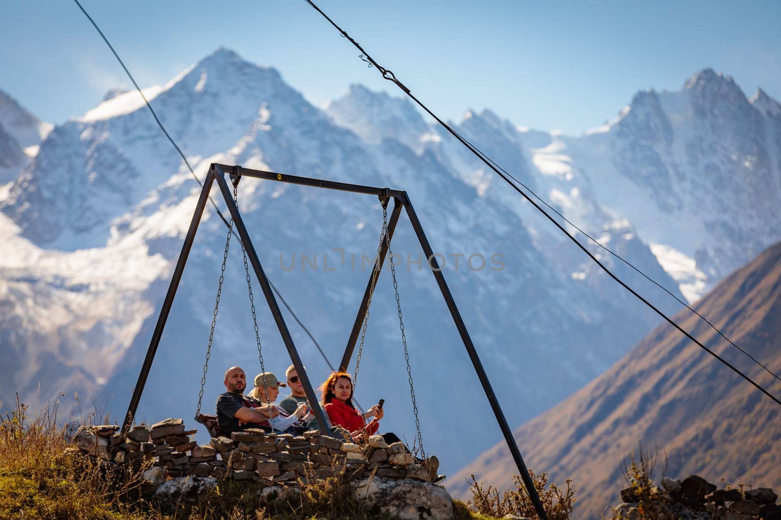 A cheerful group of friends discuss plans while enjoying the views of the majestic mountains