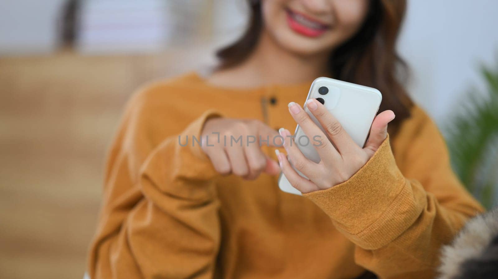 Cropped shot happy young woman typing text message on mobile phone, chatting online . by prathanchorruangsak