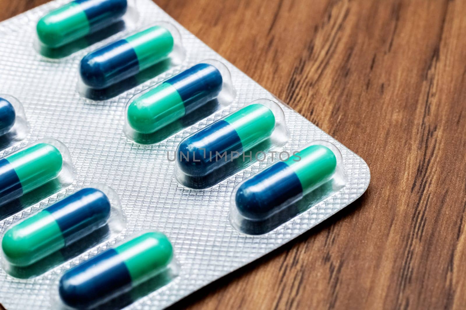 Blue pills in pack close up on wooden table