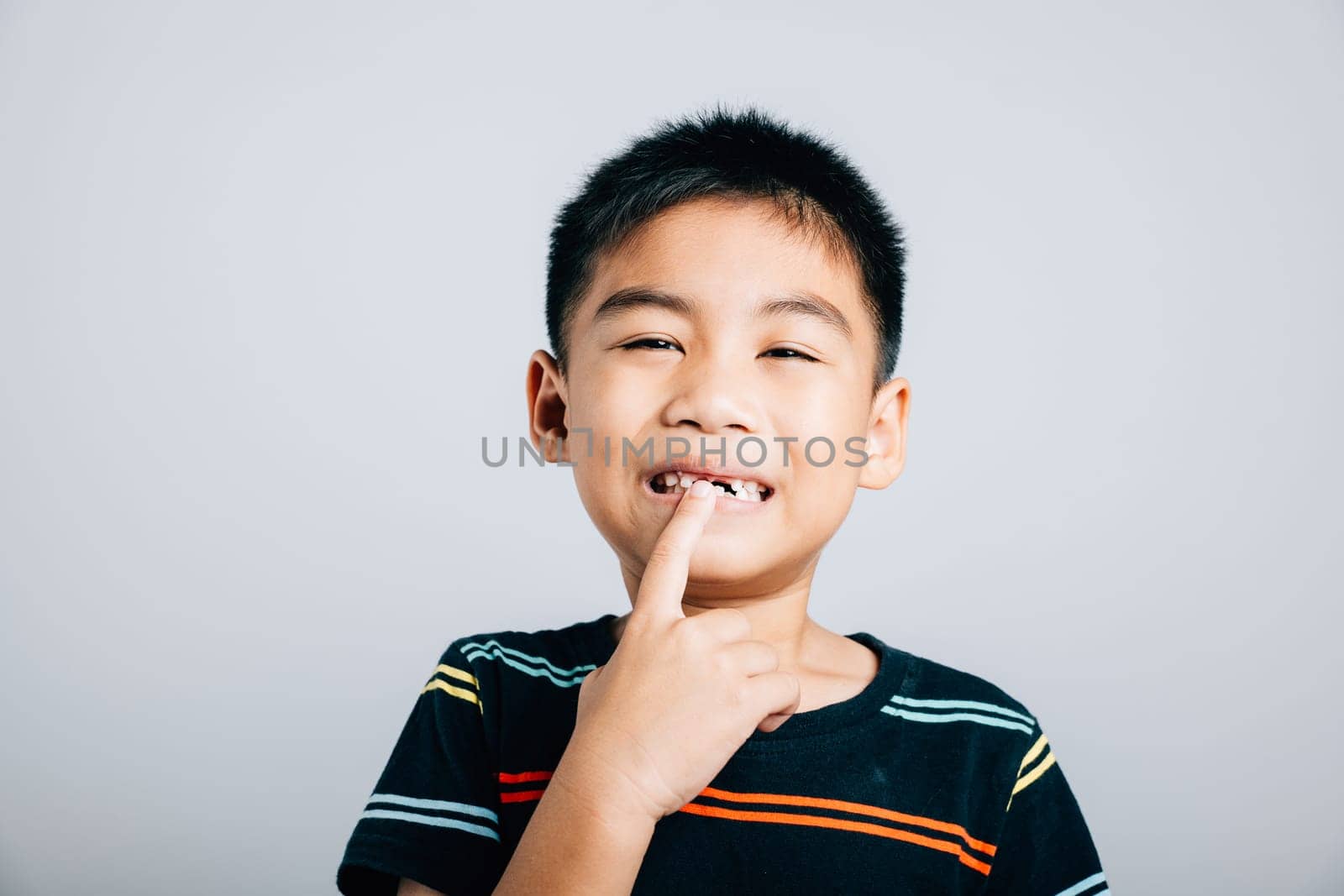 Cute boy widely smiling points to growing molar gap. joyful portrait capturing significant phase of losing baby teeth at six emphasizing dental care and development. teeth new gap dentist problems by Sorapop