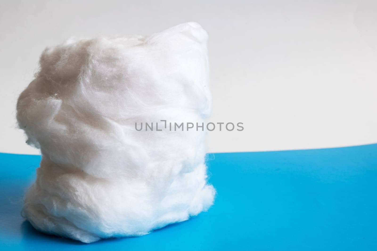 Roll of medical cotton wool on blue background by Vera1703