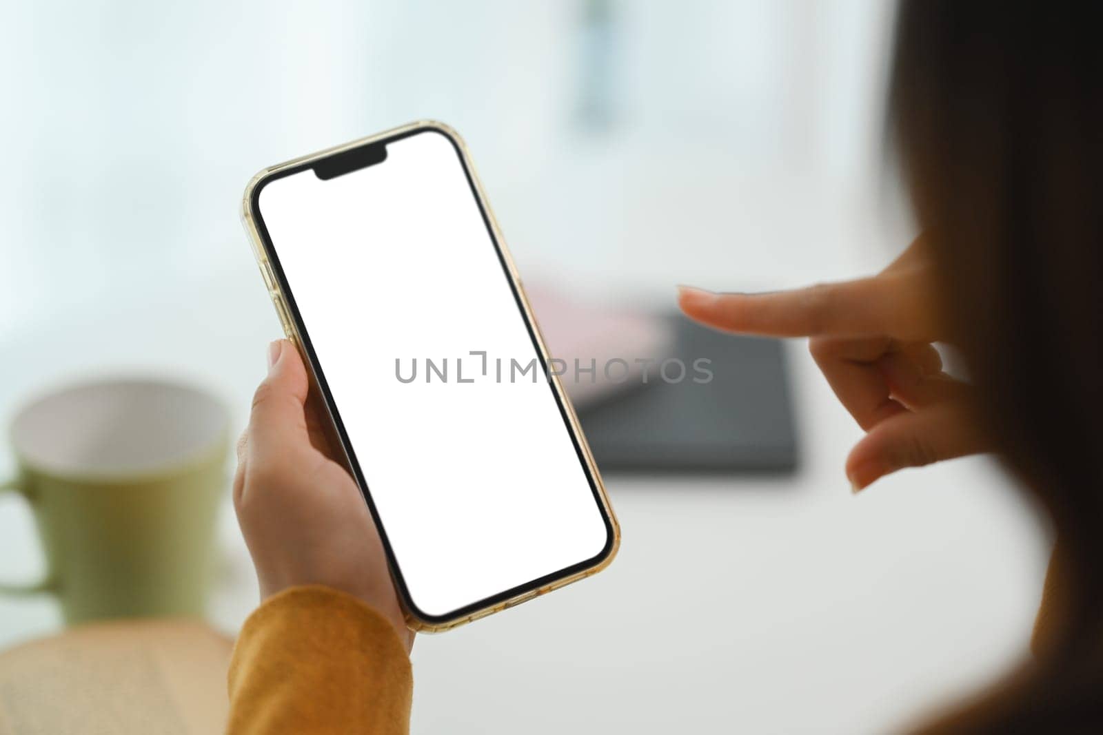 Closeup woman hands holding mobile phone with empty screen for advertising or message.