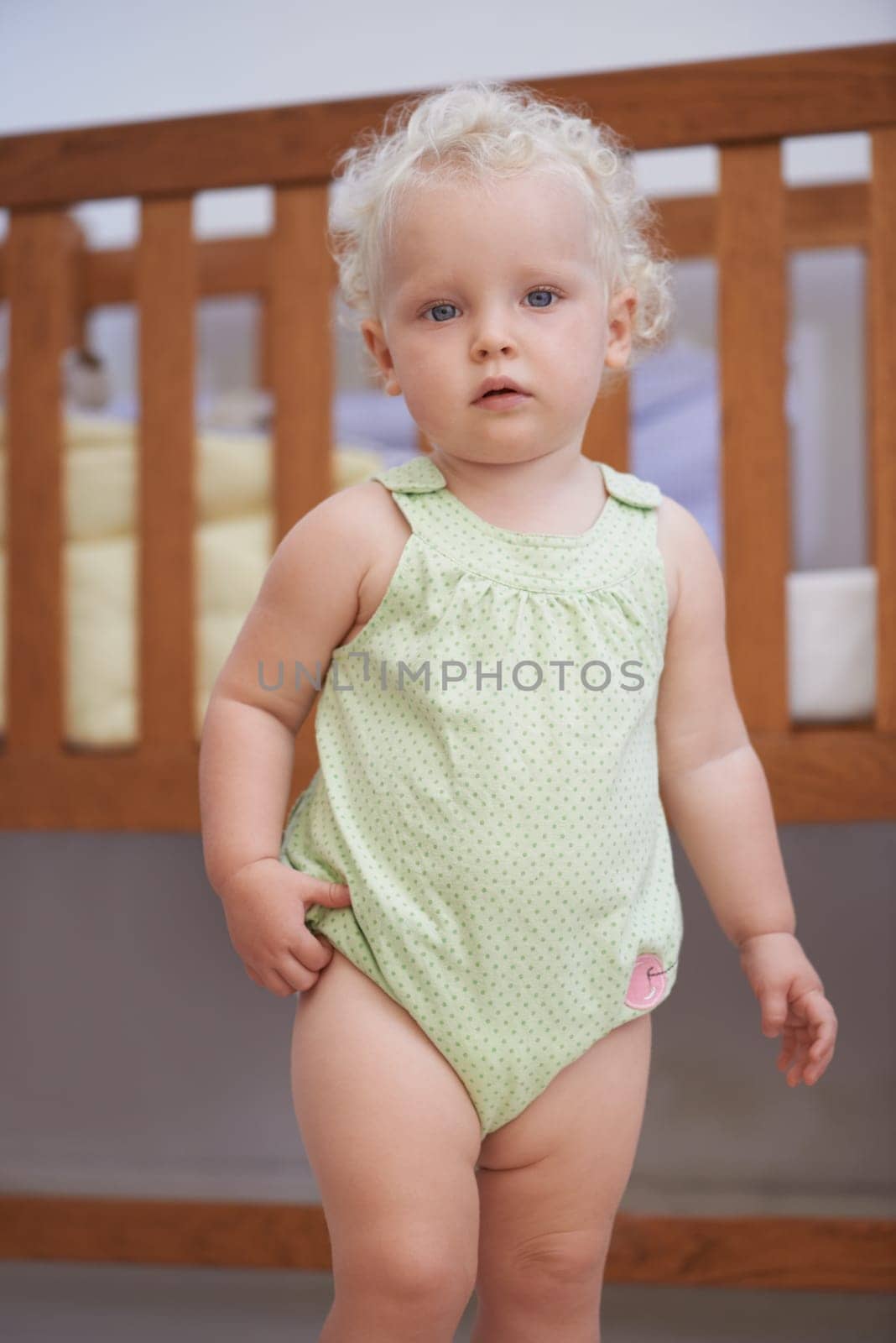 Portrait, baby and kid at nursery in home, adorable and cute innocent child alone in house. Young blonde toddler, health and childhood development for growth of girl standing by crib in Switzerland.
