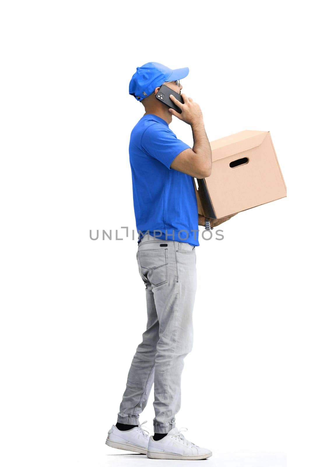 A male deliveryman, on a white background, in full height, with a box and a phone.