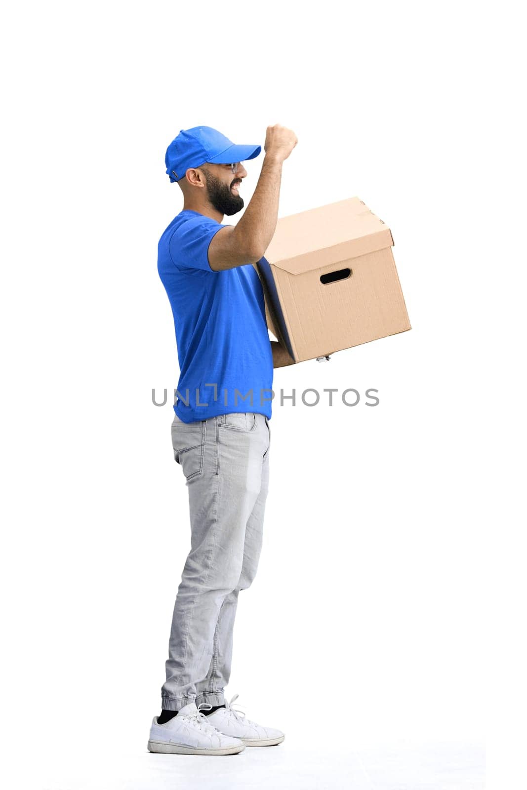 A male deliveryman, on a white background, full-length, with a box, raised his hand up by Prosto