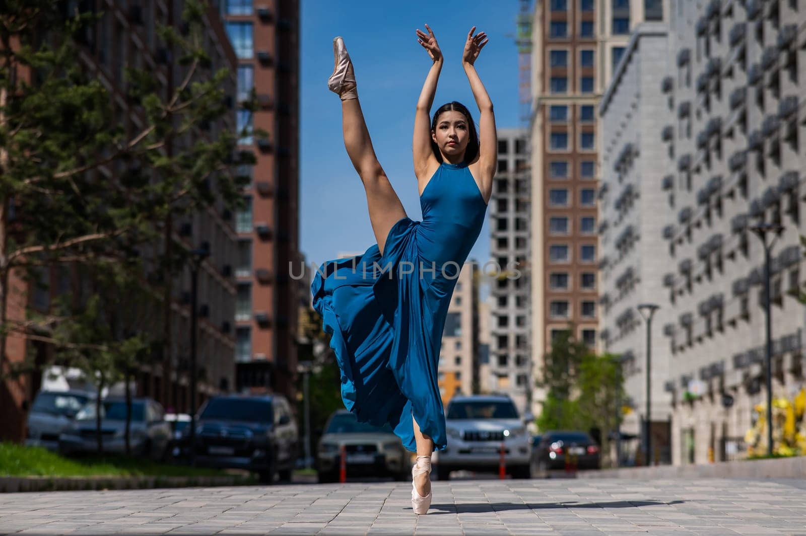 Beautiful Asian ballerina dancing outdoors. Urban landscape. by mrwed54