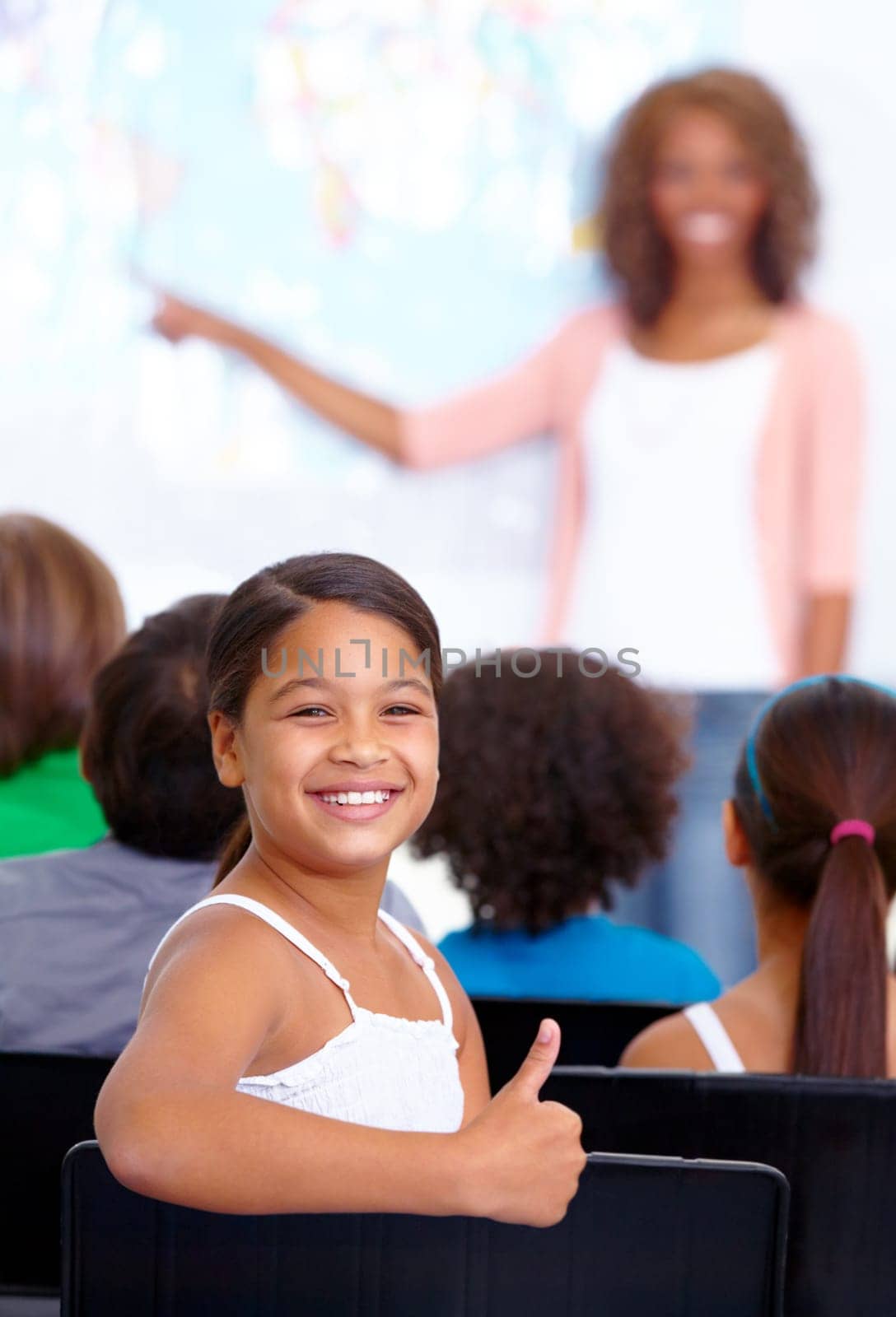 Happy student, portrait and child with thumbs up in class for winning or success together at school. Young female person, kid or girl smile with like emoji, yes sign or OK for education in classroom.