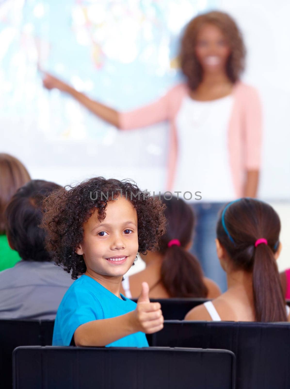 Happy student, portrait and kid with thumbs up in class for winning or success together at school. Young male person, child or boy smile with like emoji, yes sign or OK for education in classroom.