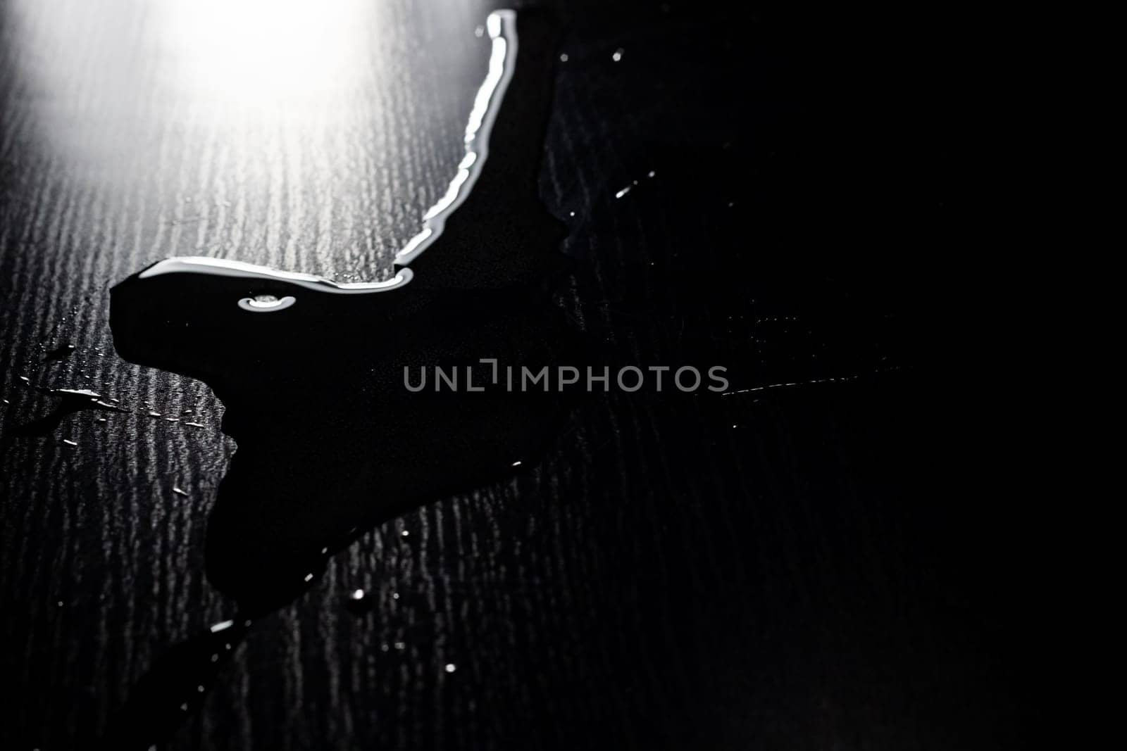 Water spilled on a black table close up by Vera1703
