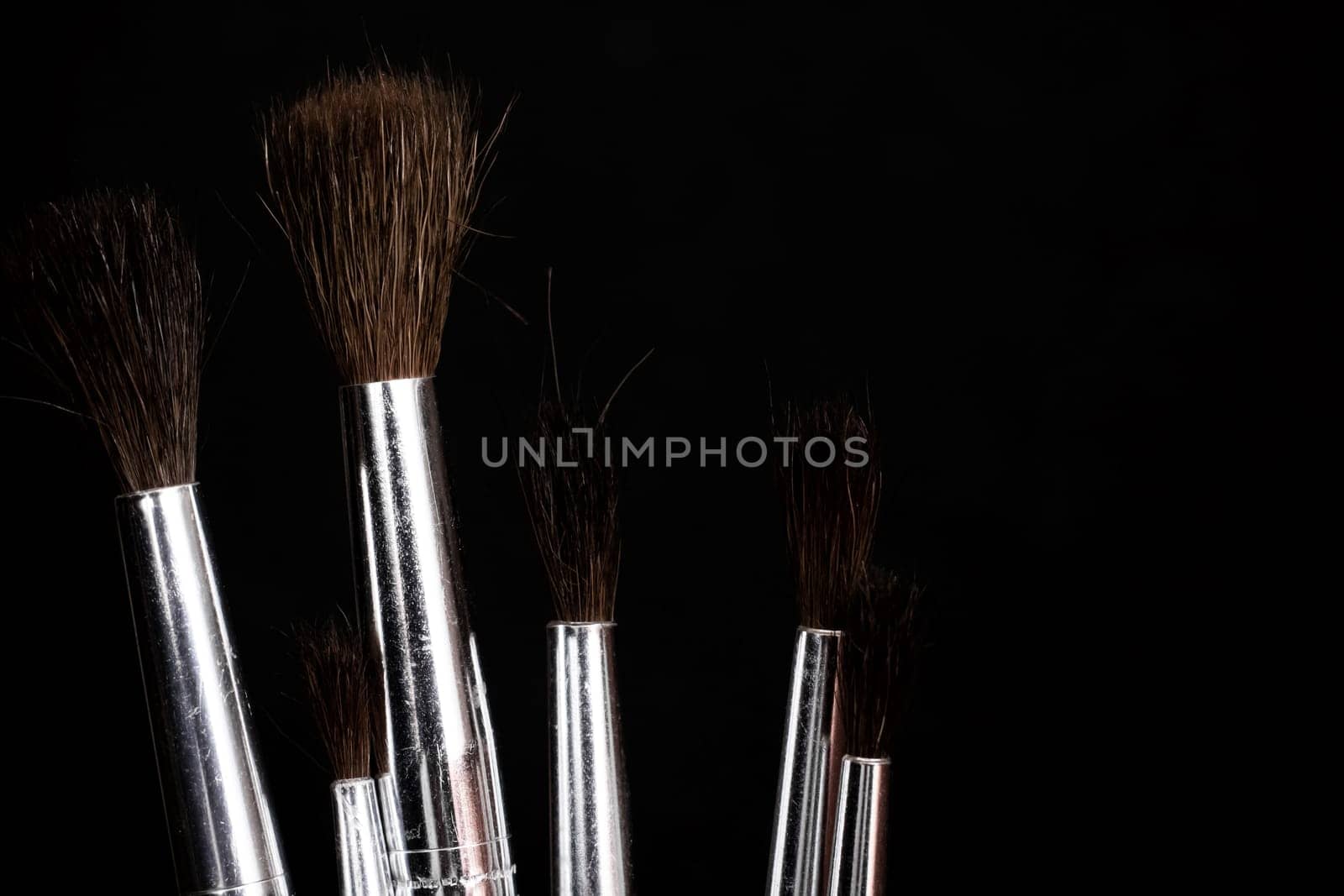 Paint brushes close up on a dark background, copy space