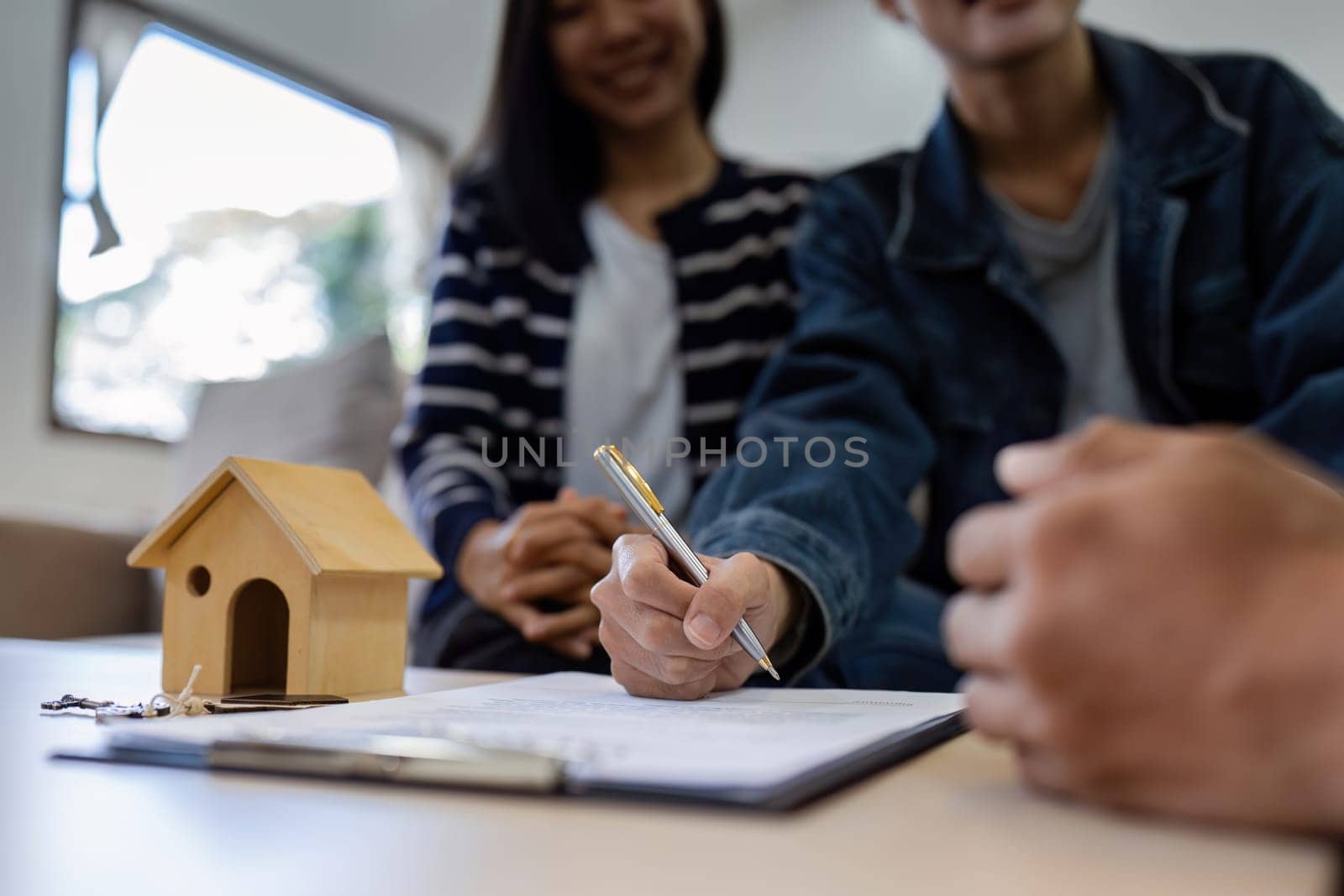 young lesbian married couple hand hold stylus and put signature in contract with real estate agent or broker. Professional financial advisor or saleswoman explaining contract detail by itchaznong