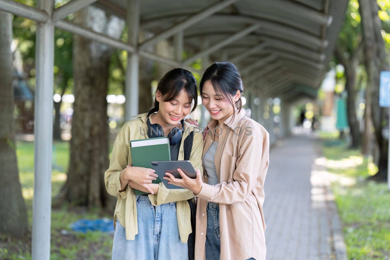 university students using a digital tablet while walking to next class.