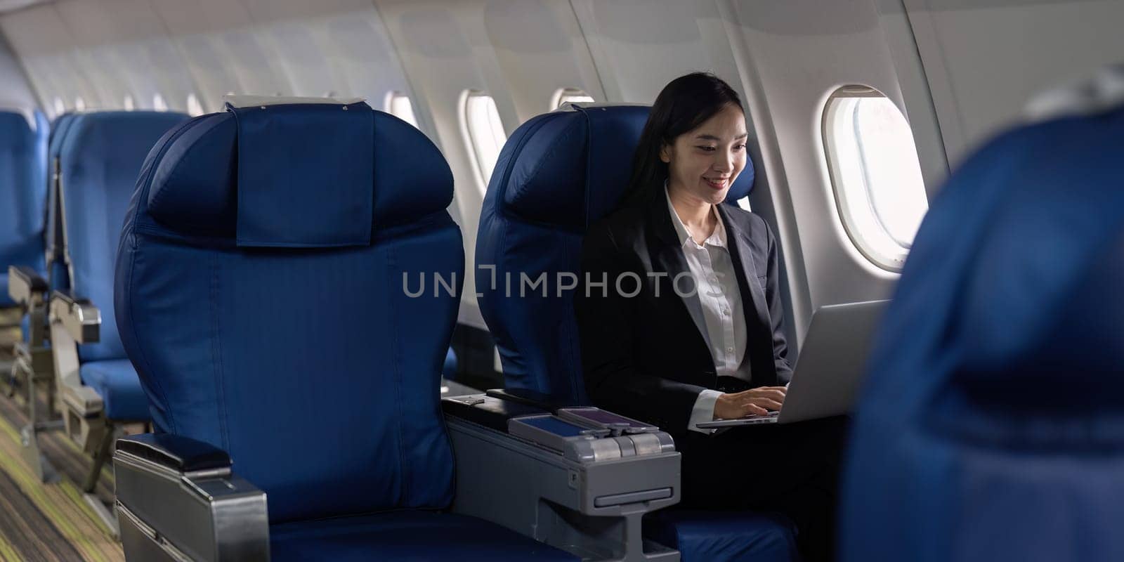 businesswoman flying and working in an airplane in first class, Man sitting inside an airplane using laptop by itchaznong