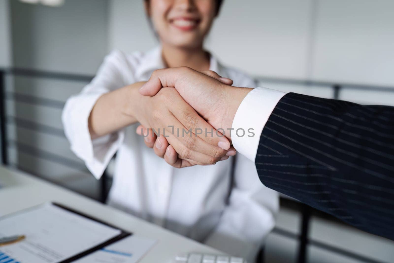 Two diverse professional business executive leader shaking hands at office after meeting.