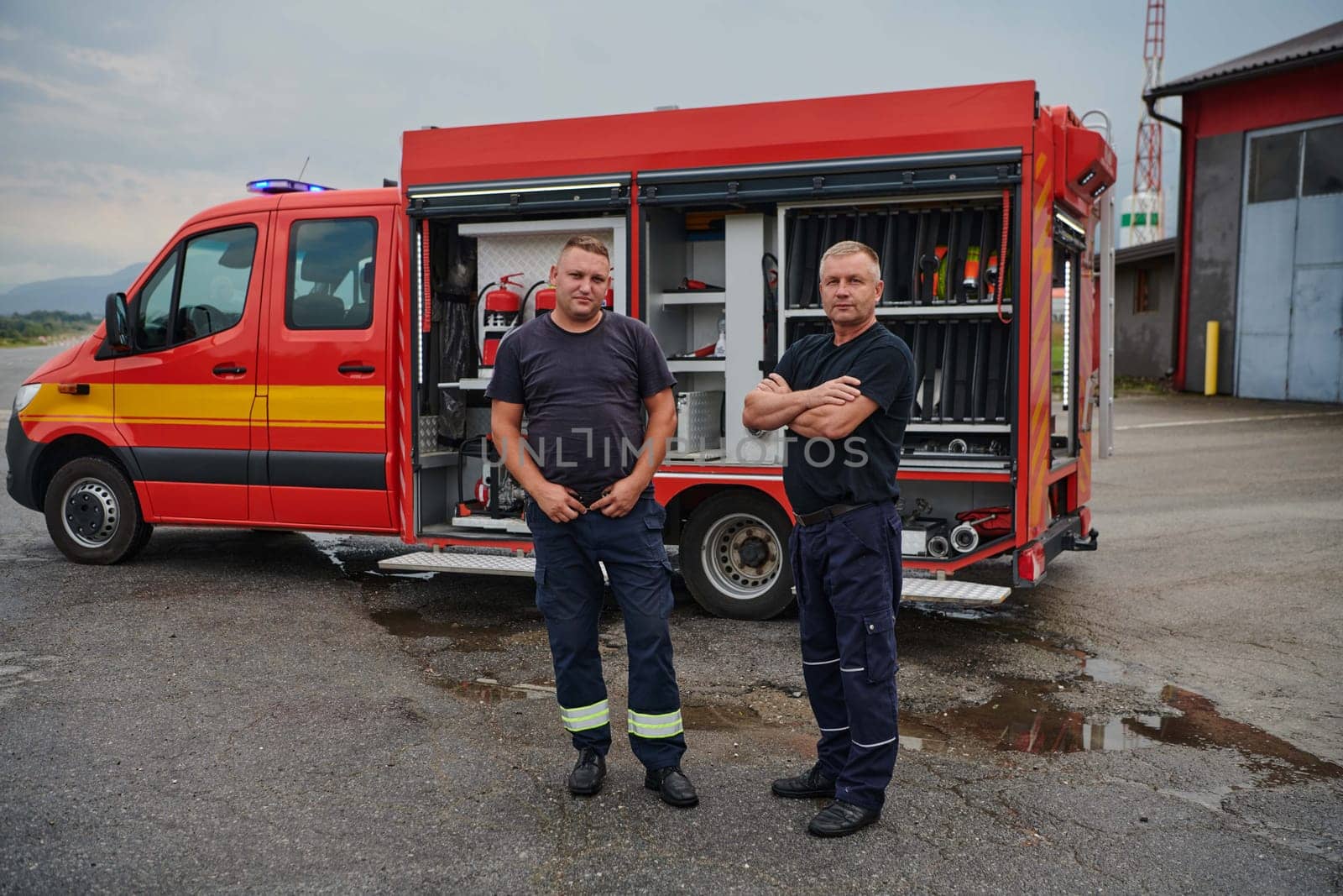 A skilled and dedicated professional firefighting team proudly poses in front of their state of the art firetruck, showcasing their modern equipment and commitment to ensuring public safety