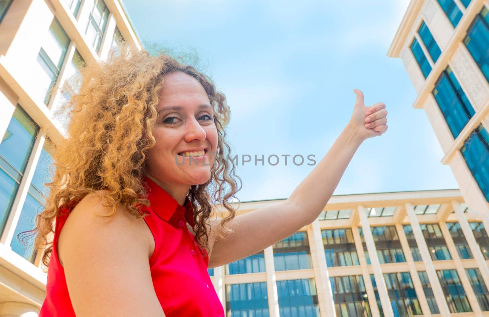 Portrait happy fasion woman shows thumb up against the sky and looking and looks sideways and up. concept of good and happy