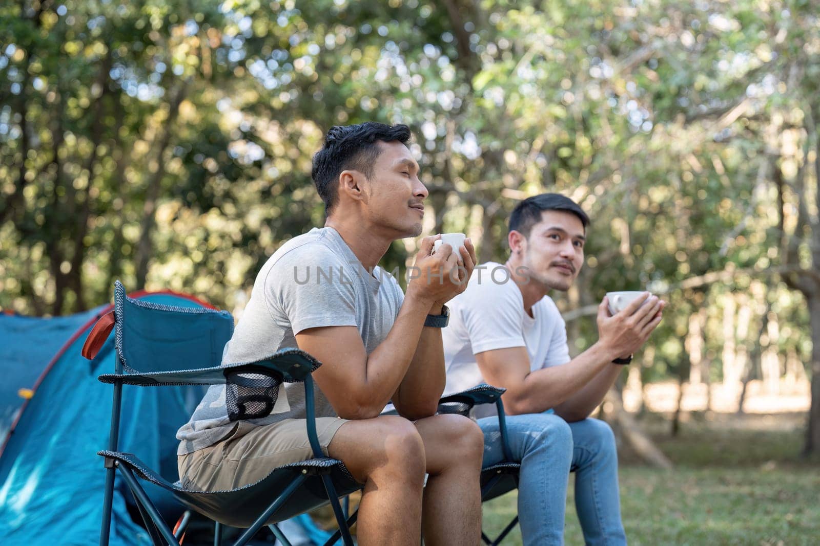 Happy Asian male gay couple on camping together in a forest. romantic vocation trip. lgbt concept.