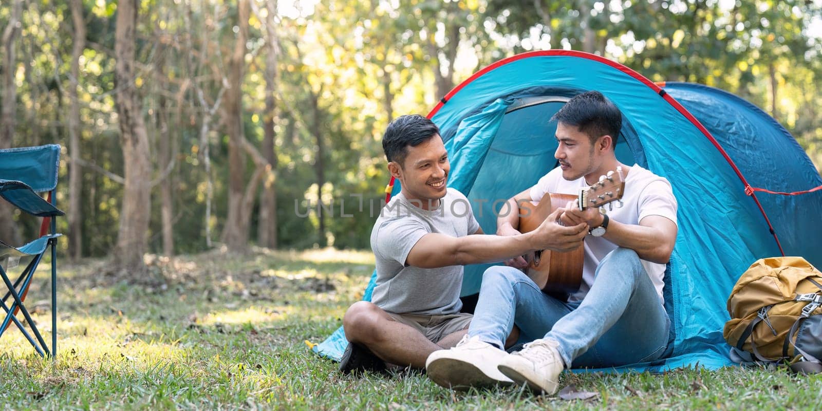 Happy Asian male gay couple on camping together in a forest. romantic vocation trip. lgbt concept by nateemee