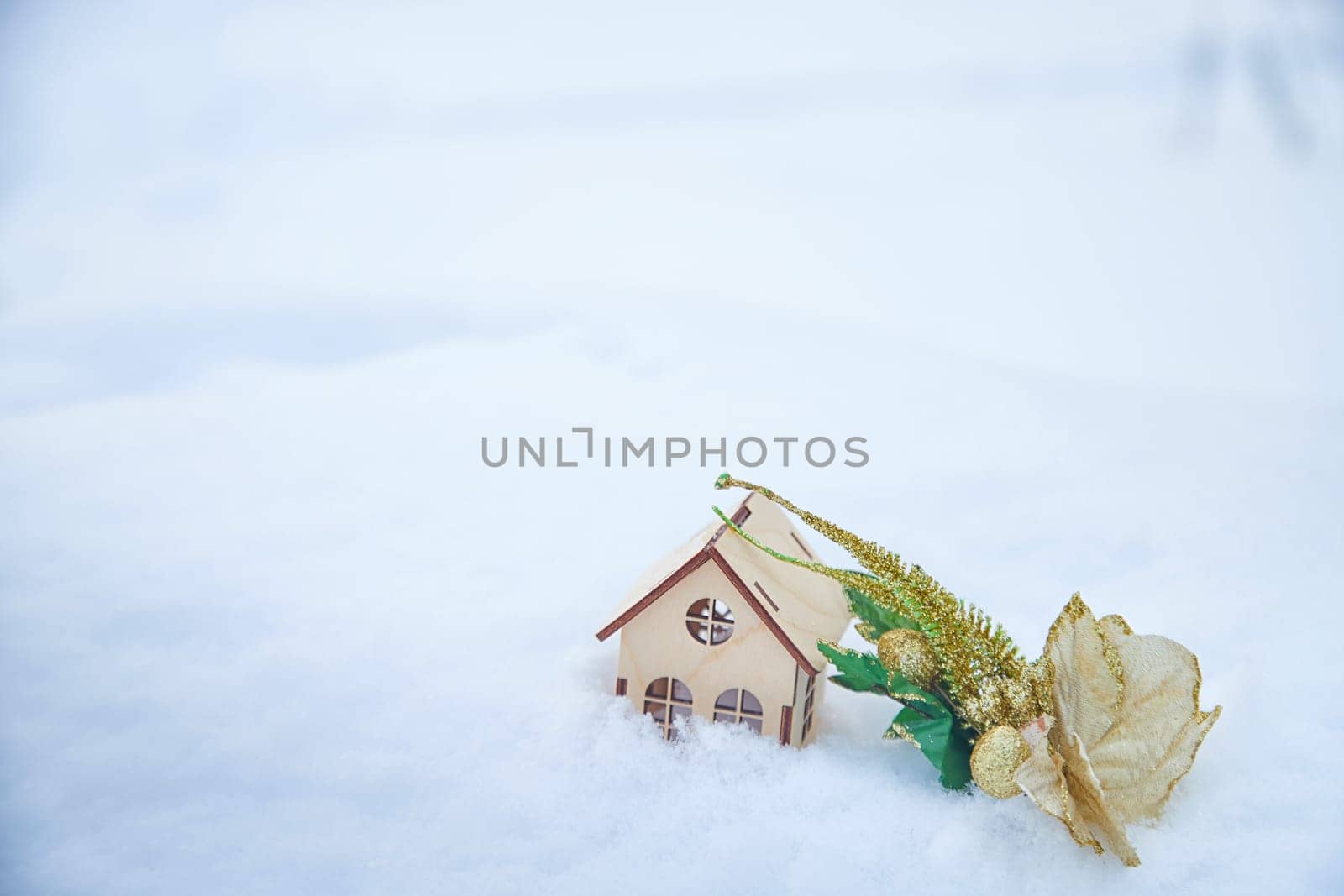 Wooden toy house on snow, natural abstract background. winter season concept. symbol of cozy, loving family home. construction, sales, rental concept. Christmas and new year holidays. copy space