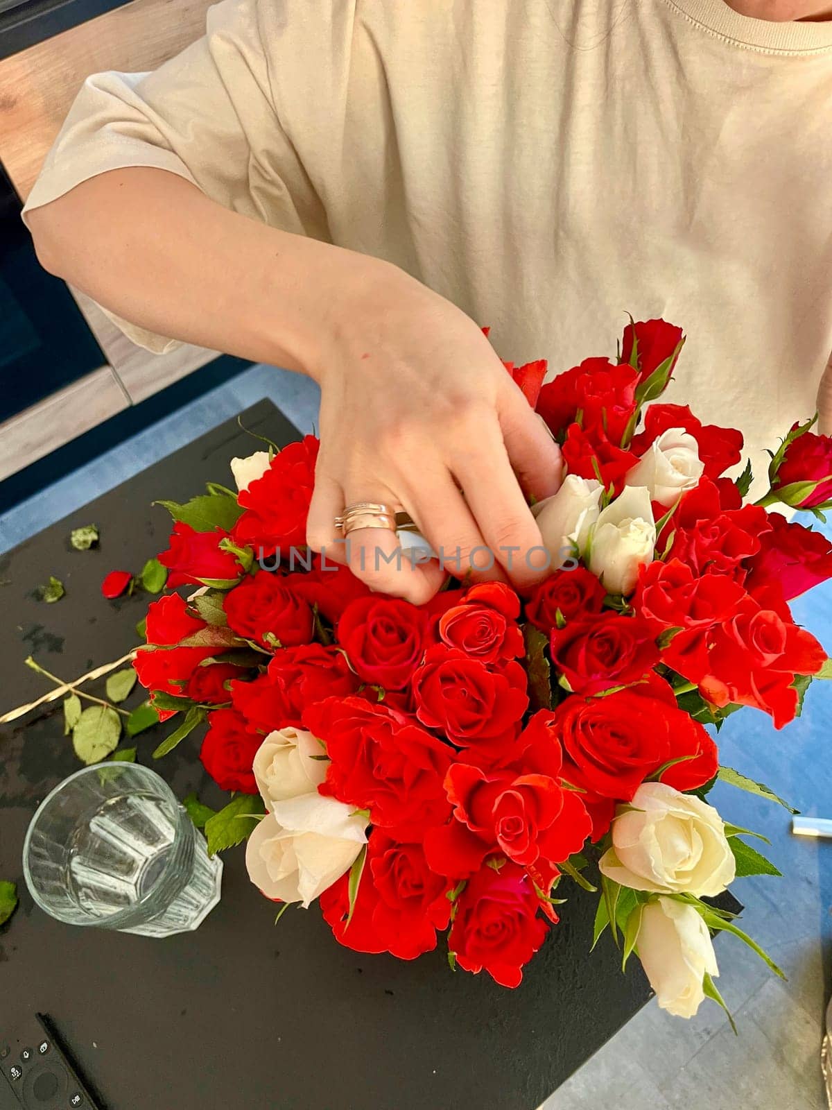 Female hands make a bouquet of red and white small roses. High quality photo