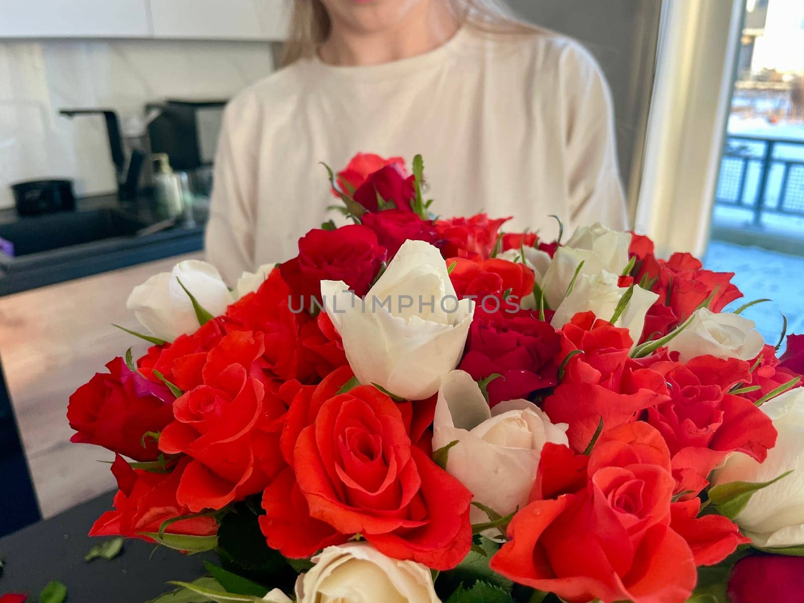 Female hands make a bouquet of red and white small roses. High quality photo
