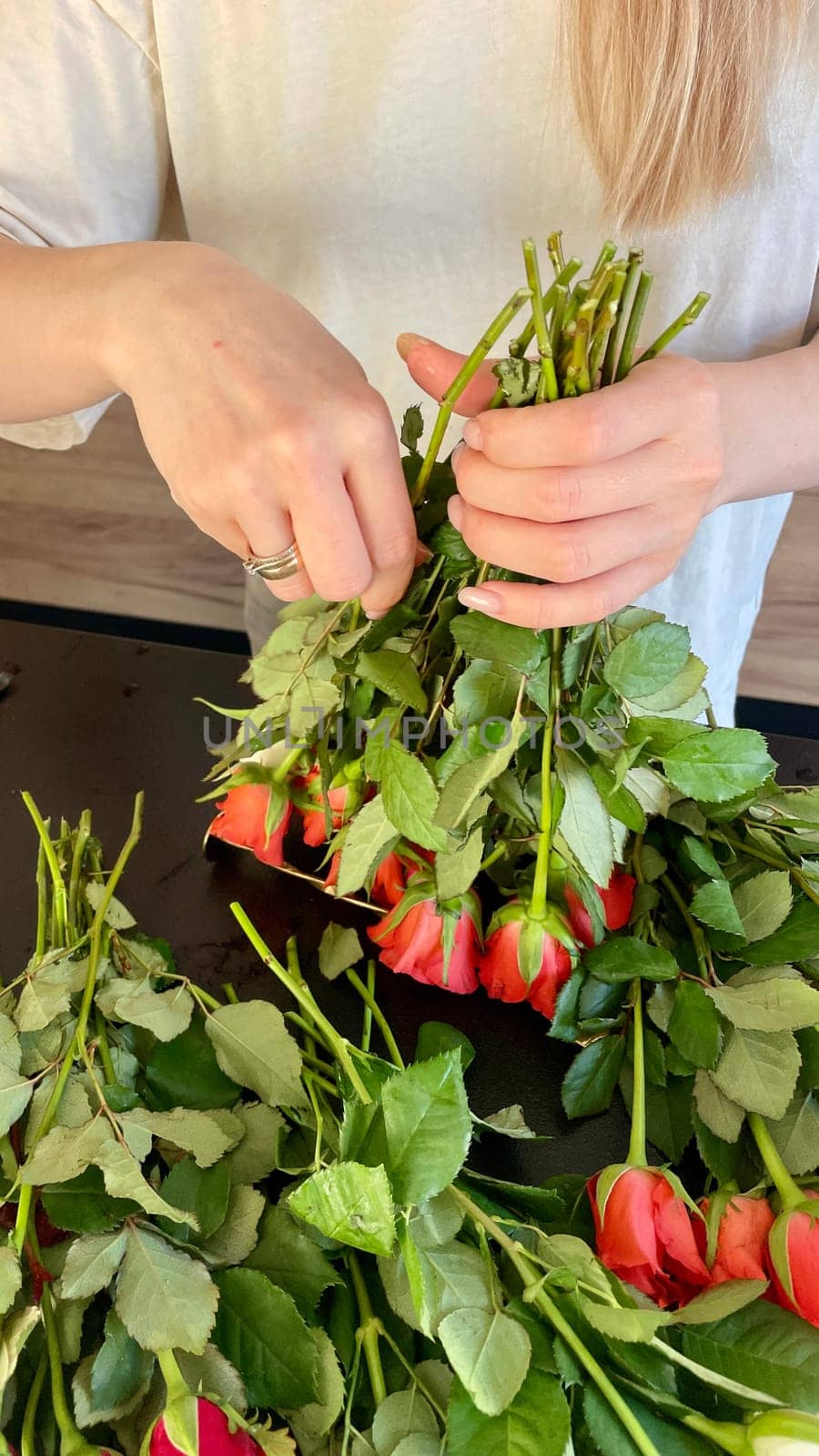 Female hands make a bouquet of red and white small roses. High quality photo