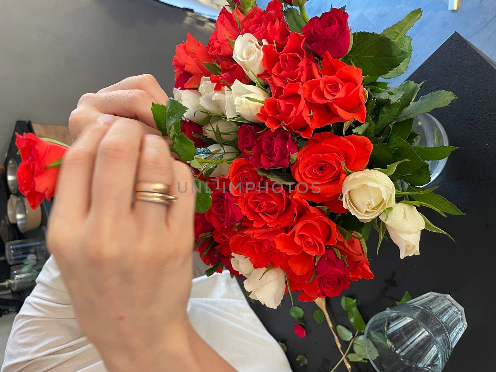 Female hands make a beautiful bouquet of red and white small roses by MilaLazo