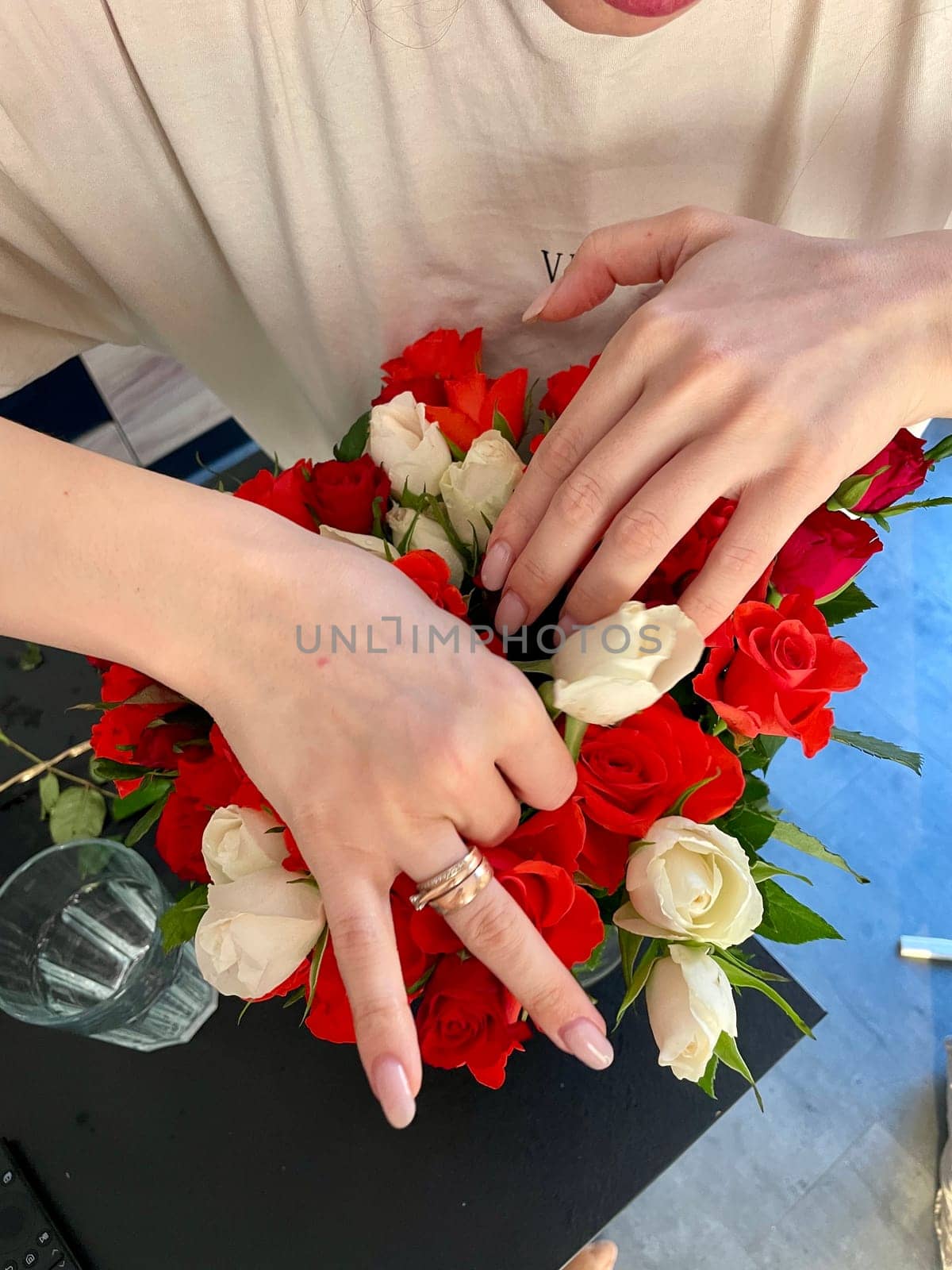 Female hands make a bouquet of red and white small roses. High quality photo