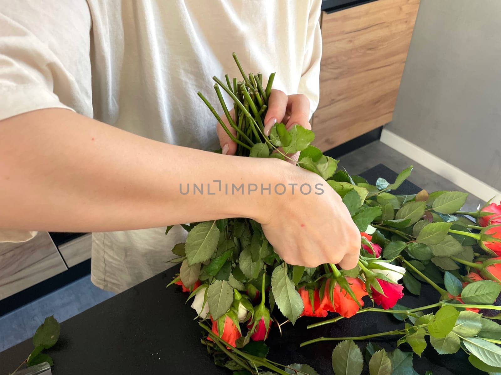 Female hands make a bouquet of red and white small roses. High quality photo